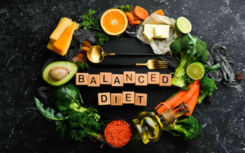 balanced-diet-inscription-avocado-carrot-orange-broccoli-dried-fruits-nuts-parsley-top-view-free-space-your-text (1)